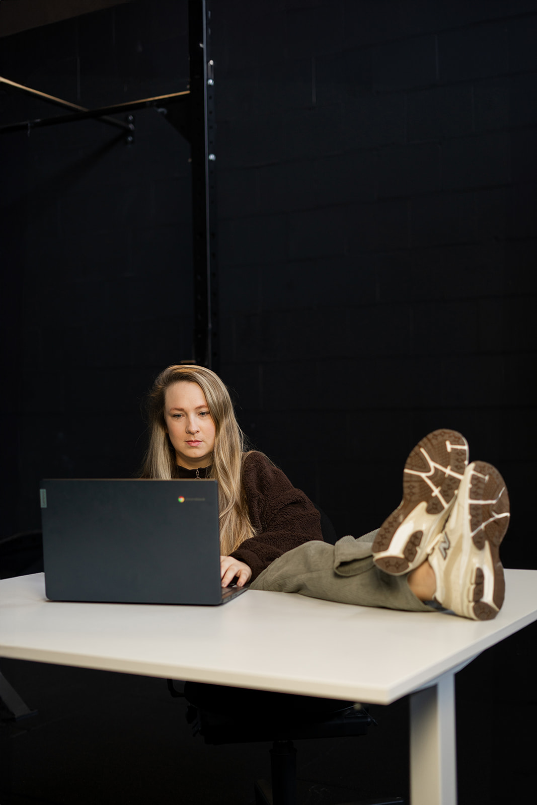 Melanie Verbueken achter haar laptop in de sportschool